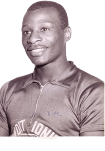 Black-and-white vintage photograph of a male athlete smiling, wearing a collared shirt.